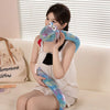 A young woman is holding a colorful, plush cartoon snake toy against her face.