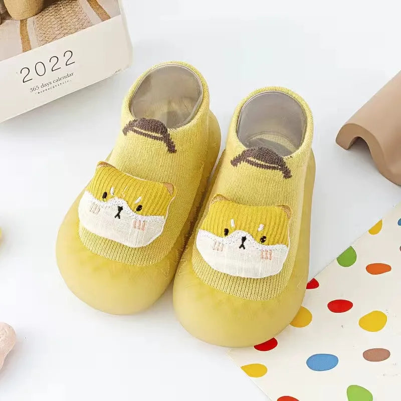 A pair of yellow animal soft sole sock shoes for babies and toddlers with cute cat designs