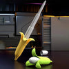 A yellow banana-shaped katana toy with a white blade and green leaves rests on a dark surface.