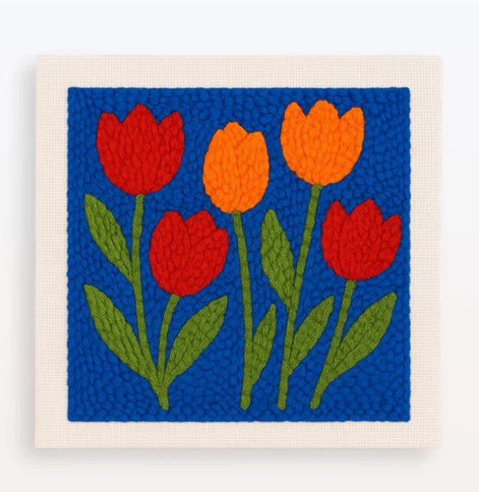 Punch needle embroidery kit featuring red and orange tulip flowers on a blue background