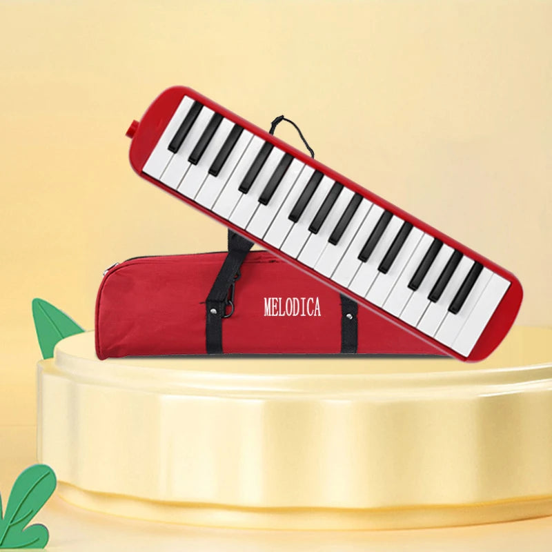 A red 32-key portable melodica is shown lying on a yellow stand with its carrying bag attached.