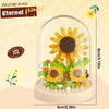 A clear glass terrarium shows a DIY flower bouquet made of colorful building blocks with a sunflower as the centerpiece.
