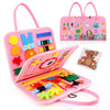 A pink Montessori busy board for toddlers featuring various colorful manipulative items and a matching tote bag.