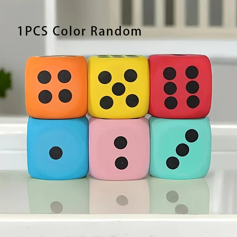 Three jumbo soft foam dice in orange, yellow, and red colors are displayed on a white surface.
