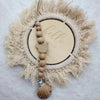 A personalized wooden baby pacifier clip featuring silicone beads and a feather-like natural fiber wreath.