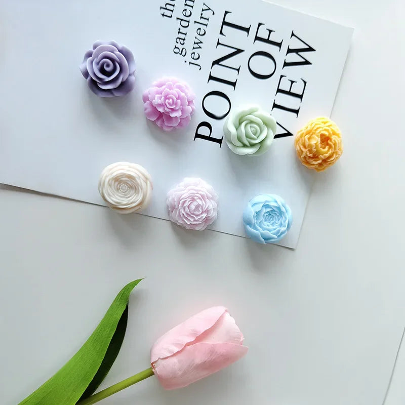 A collection of pastel pink and green 3D flower silicone molds arranged on a white background.