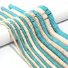 A close-up of numerous strands of natural turquoise stone beads in shades of blue and white, laid out on a white surface.