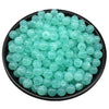 A pile of light aqua clear acrylic round beads for jewelry making in a black bowl.