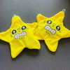 Two yellow star-shaped plush keychains with angry facial expressions