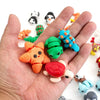A hand holds a collection of colorful poseable 3D printed animal figurines.