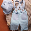 A light blue knit romper and matching newsboy cap set for a newborn boy.