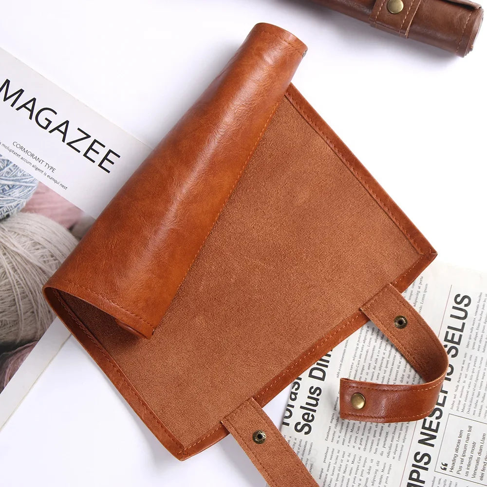 A brown PU leather storage bag designed to hold dice, shown next to a magazine.