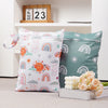 A set of two reusable waterproof baby wet bags featuring colorful rainbows and suns on a light background.