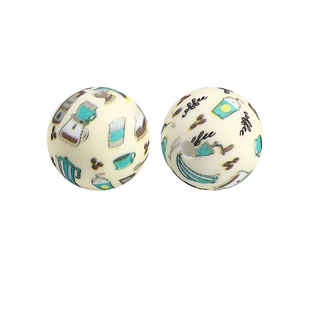Two round silicone beads with a light background decorated with small turquoise and silver prints