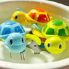 A collection of colorful wind-up swimming turtle bath toys floating in water.