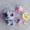 A set of three small purple and pink animal figures, including an elephant, sitting on a gray surface.