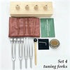 A set of four tuning forks made of metal and wood for sound healing and meditation.