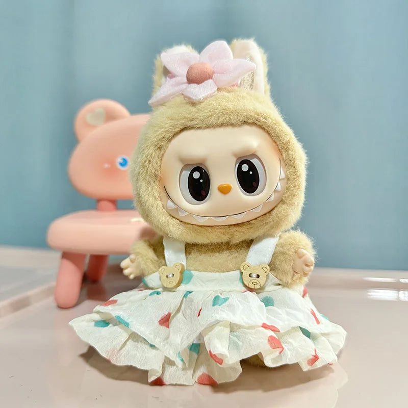 A light yellow plush doll wearing a white ruffled dress and pink flower accessory.
