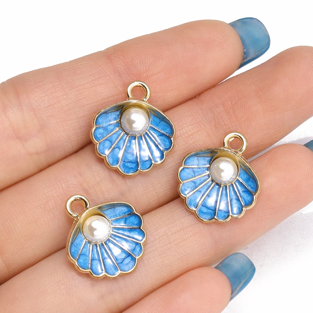 Gold-toned enamel marine life charms featuring blue and white scales and pearl accents