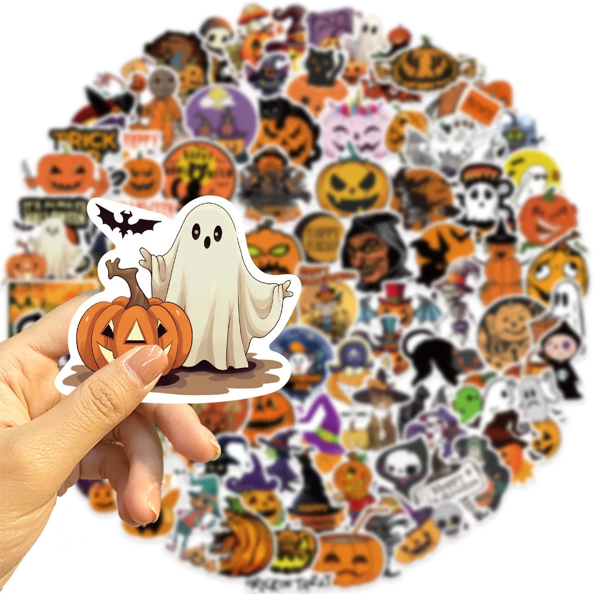 A hand holds a large collection of Halloween-themed waterproof stickers for laptops and bottles.