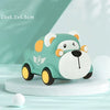 A cute, light green rubber push and go car shaped like a bear is displayed on a white surface.