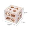 A wooden Montessori toy set with various geometric shapes cut into a box for toddlers.