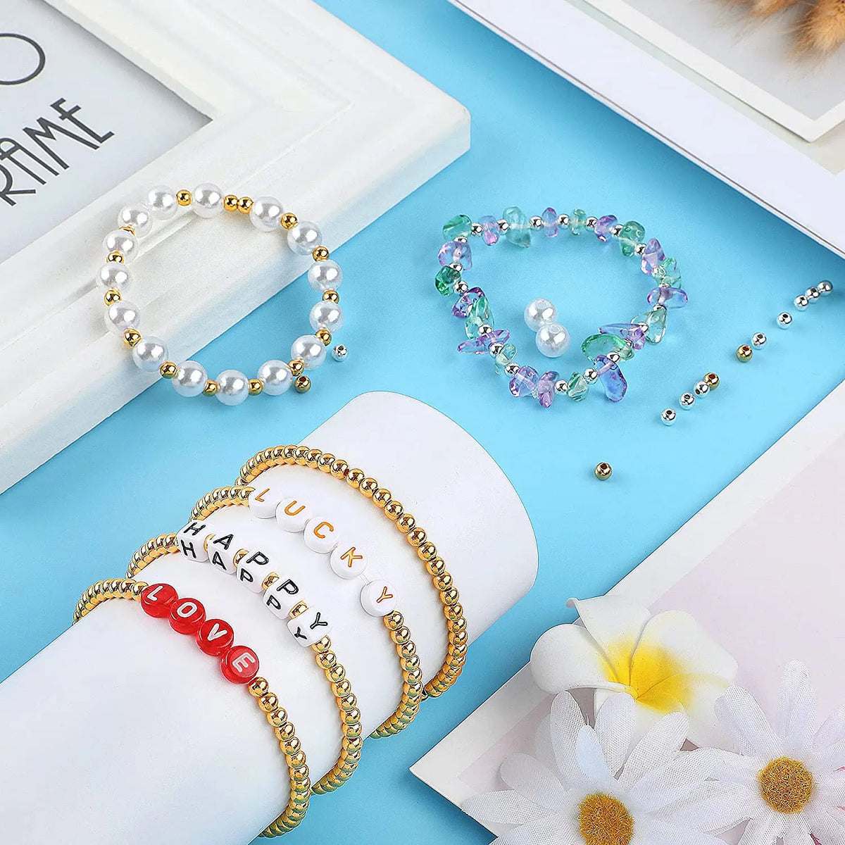 A collection of pearl and gemstone round spacer beads for DIY jewelry making displayed on a light blue background.
