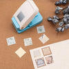 Un outil de perforation pour timbres carré, avec divers timbres perforés sur une surface marron.
