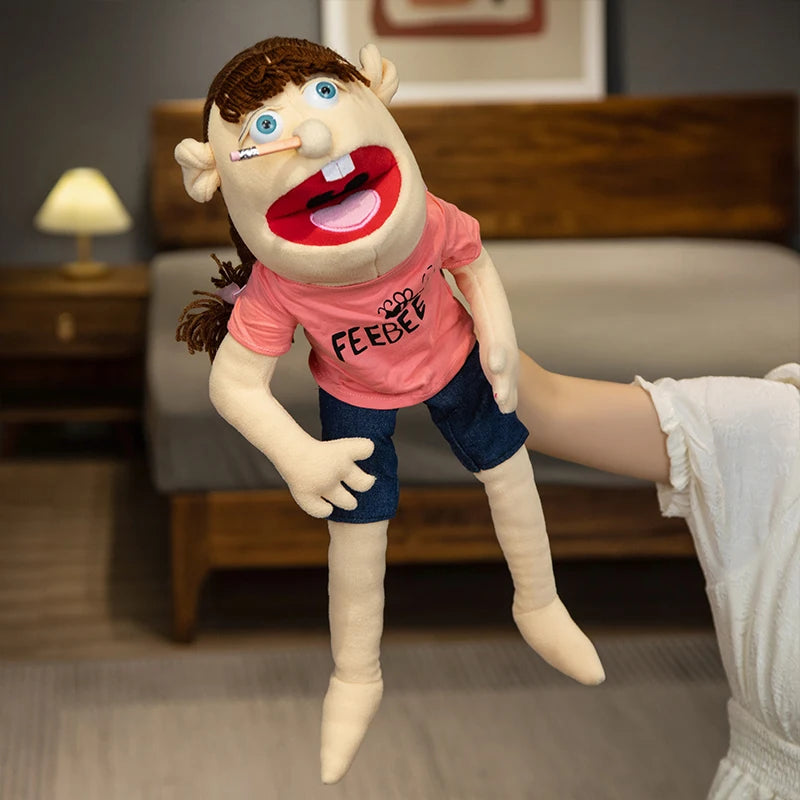 A realistic plush hand puppet with brown hair and a pink shirt is shown standing in front of a wooden couch.