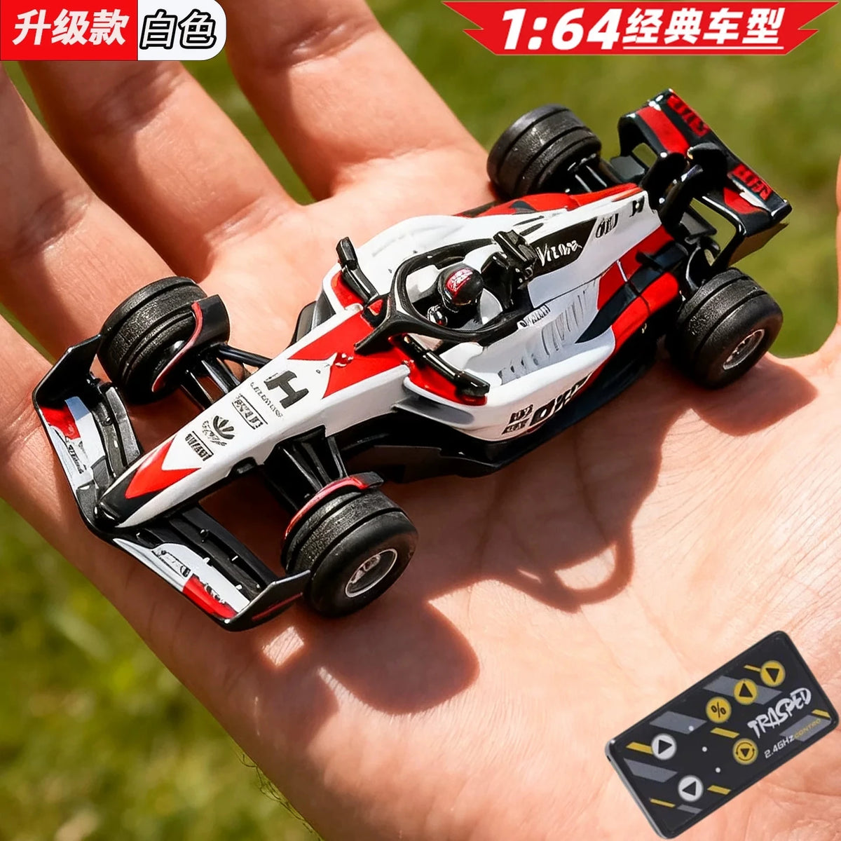 A red and white 1:64 scale alloy RC drift car is held in a person's hand outdoors.