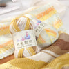 Three balls of gradient acrylic yarn in yellow and white colors displayed on a knitted fabric.