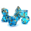 A set of six ocean blue gold foil resin dice piled together on a white surface.