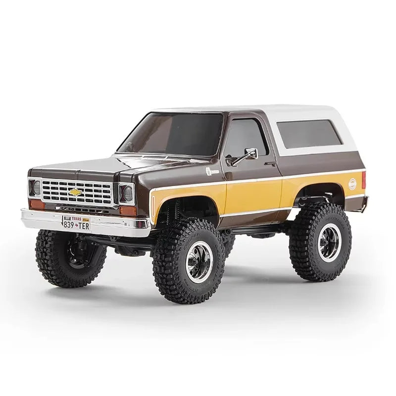 A 1:24 scale Chevrolet K5 Blazer RC crawler in brown and white paint with large off-road tires.