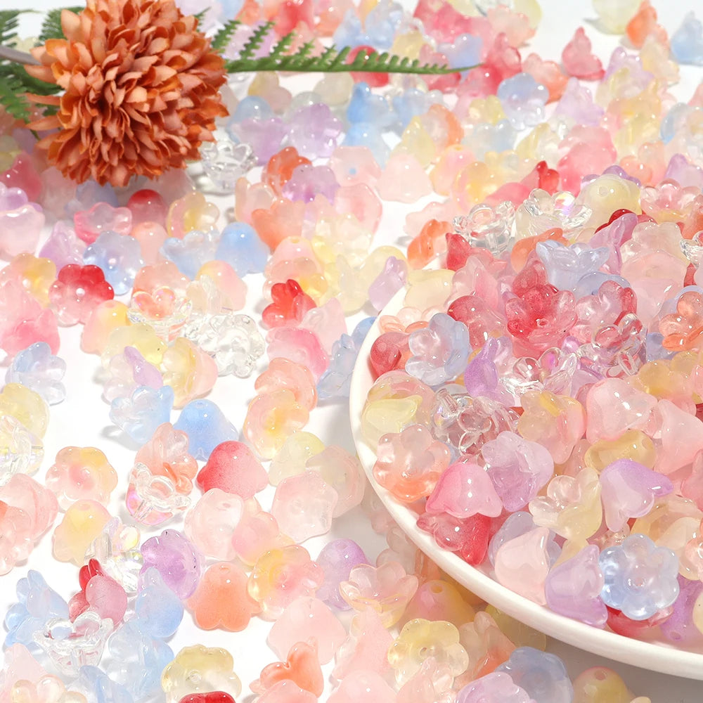 A pile of colorful, translucent cherry blossom flower glass beads in pink, yellow, and blue shades.