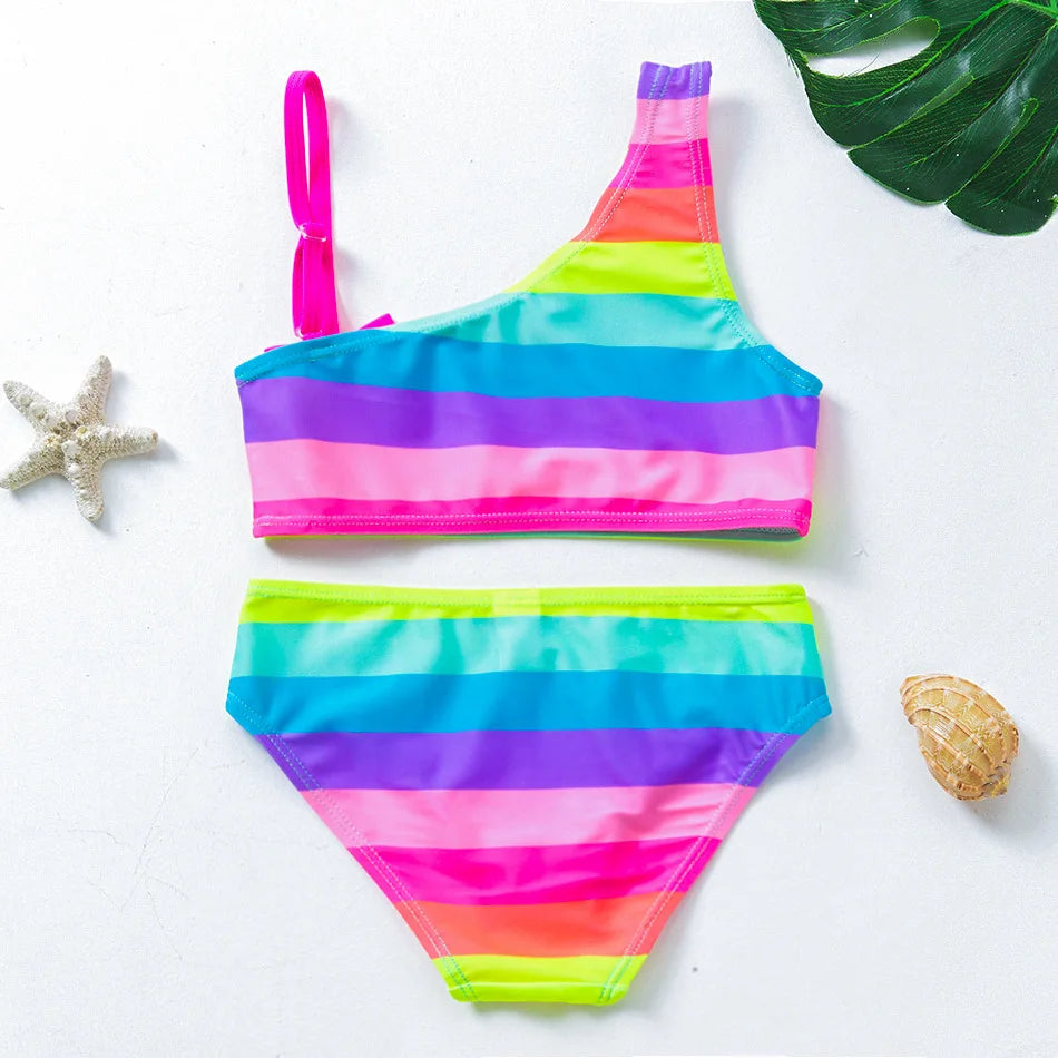 A two-piece rainbow striped swimsuit set for girls featuring pink, purple, blue, and green colors.
