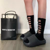 Black EVA platform slides shown next to a black tote bag