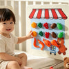 A baby is interacting with a felt board featuring colorful fruits and vegetables like tomatoes, peppers, and broccoli.