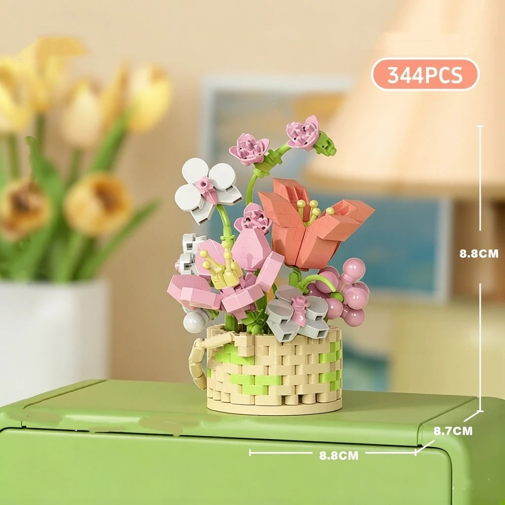 A small arrangement of pink and white flower building blocks in a woven basket on a green surface.