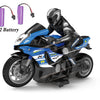 A black and blue 1:10 scale remote control stunt motorcycle with two batteries is shown.