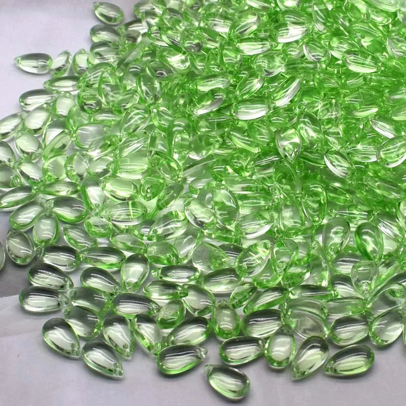 A pile of bright green water drop Czech glass beads for jewelry making