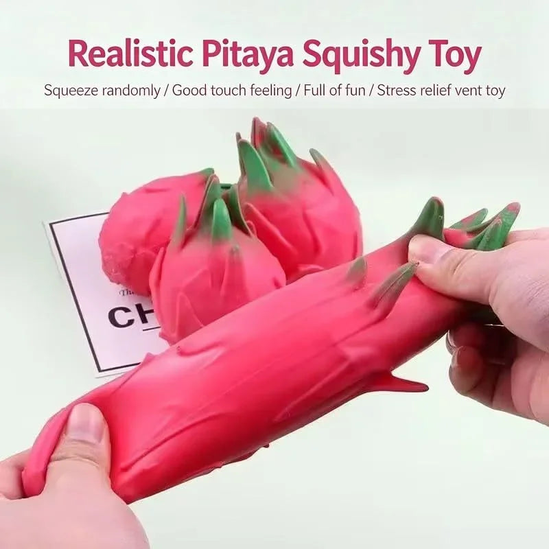 A hand squeezes a realistic pink pitaya squishy toy, showing its soft texture and vibrant color.