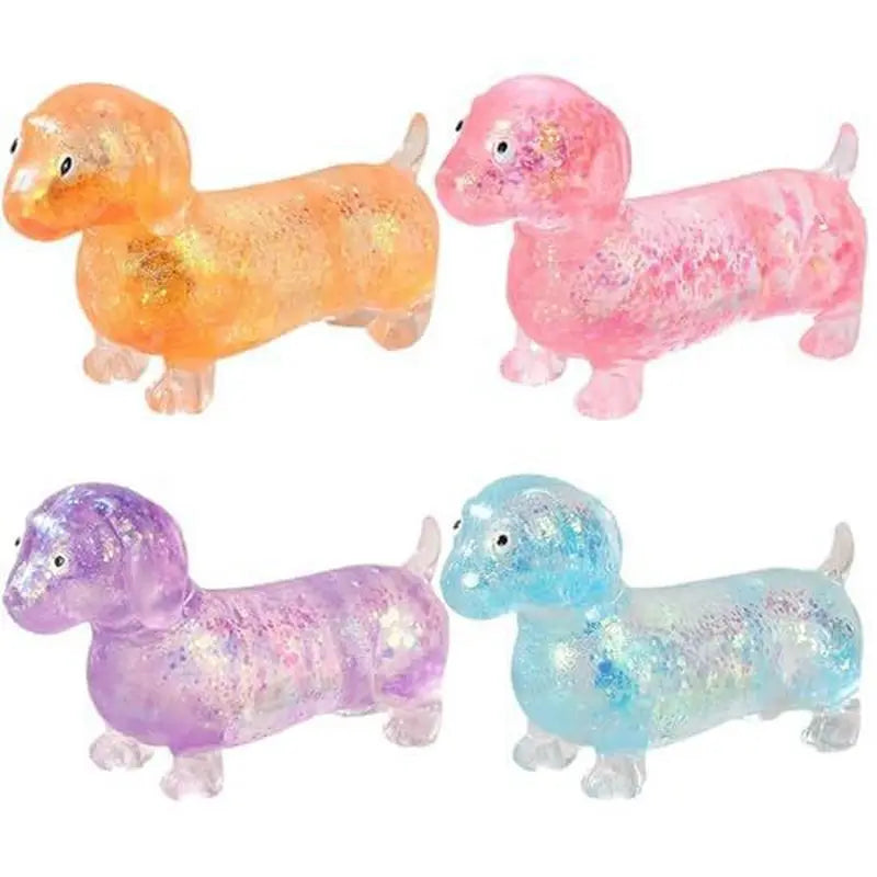 Trois jouets squish en forme de dachshund scintillants orange, rose et violet.