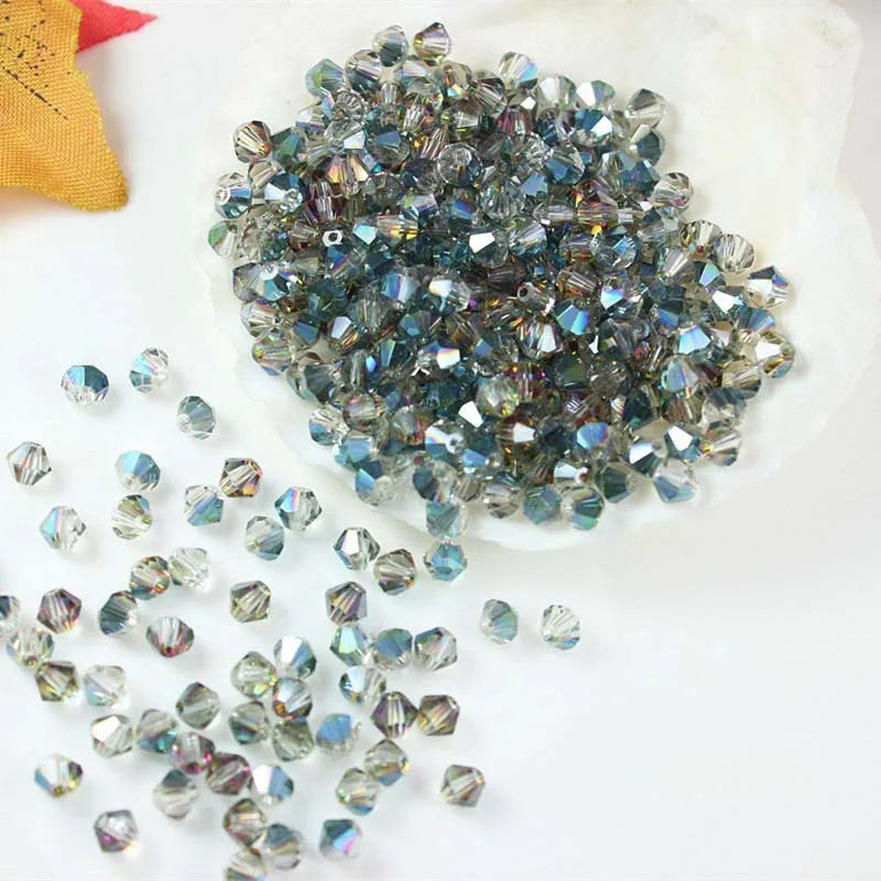A pile of multicolor faceted glass crystal beads in various sizes is displayed on a white surface.