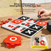 A white Tic Tac Toe board game with red and black pieces and corresponding cards shown on a wooden table.