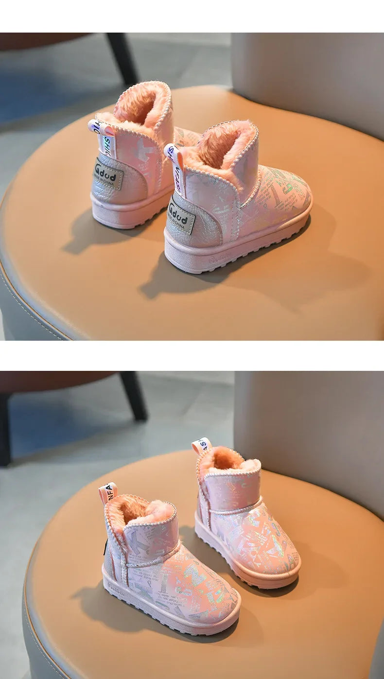 A pair of pink winter snow boots with faux fur lining and a non-slip sole resting on a light brown surface.