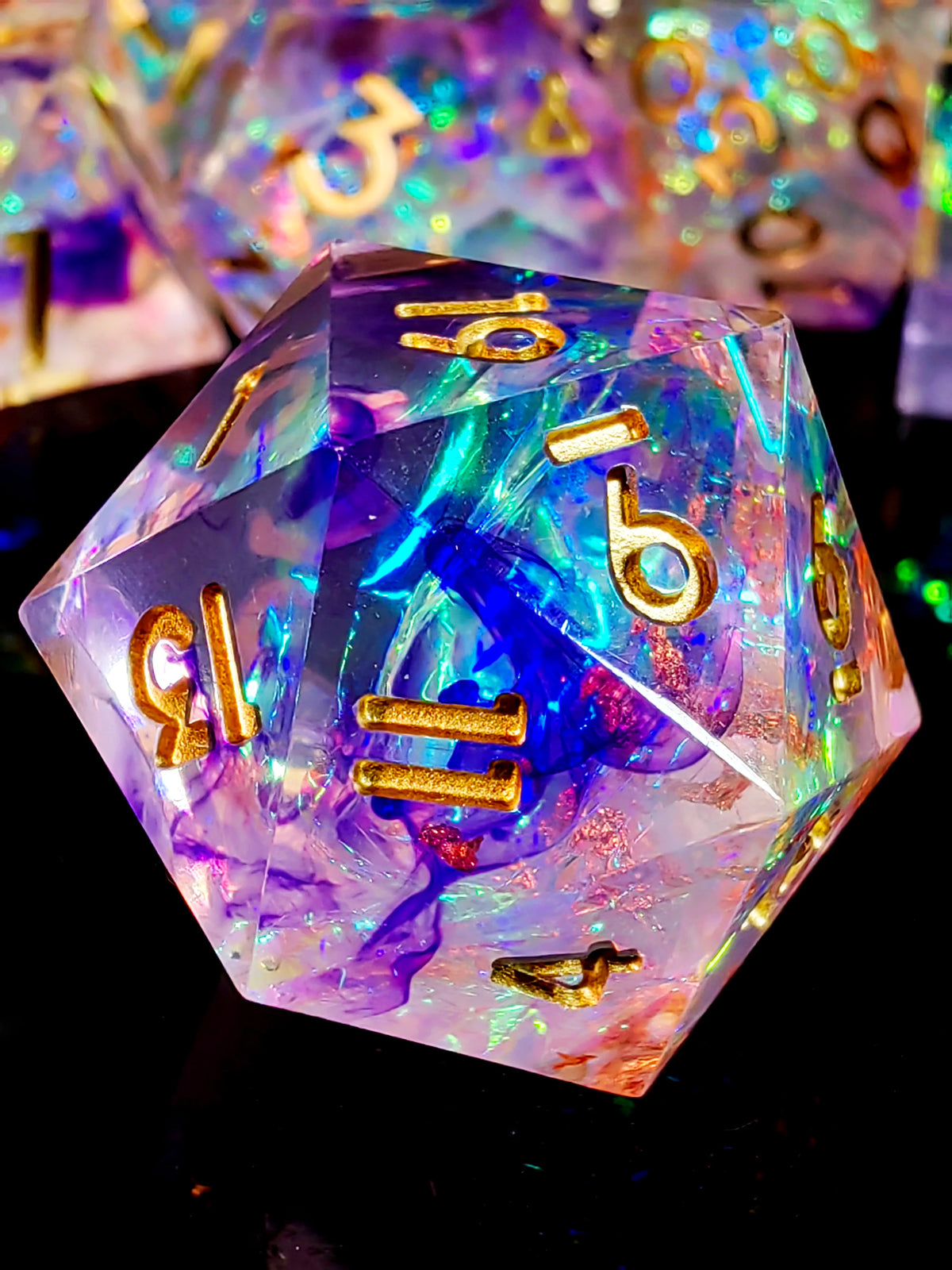 A translucent resin polyhedral die with light purple and blue iridescent colors and gold numbers