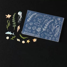 A clear silicone mold featuring various sea life designs including starfish, shells, and marine creatures.
