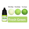 A set of liquid candle wax pigment drops in various quantities: one, five, and ten drops, shown alongside a green product lab
