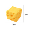 A yellow cheese squishy stress relief toy shaped like a cube, shown from the top and side.