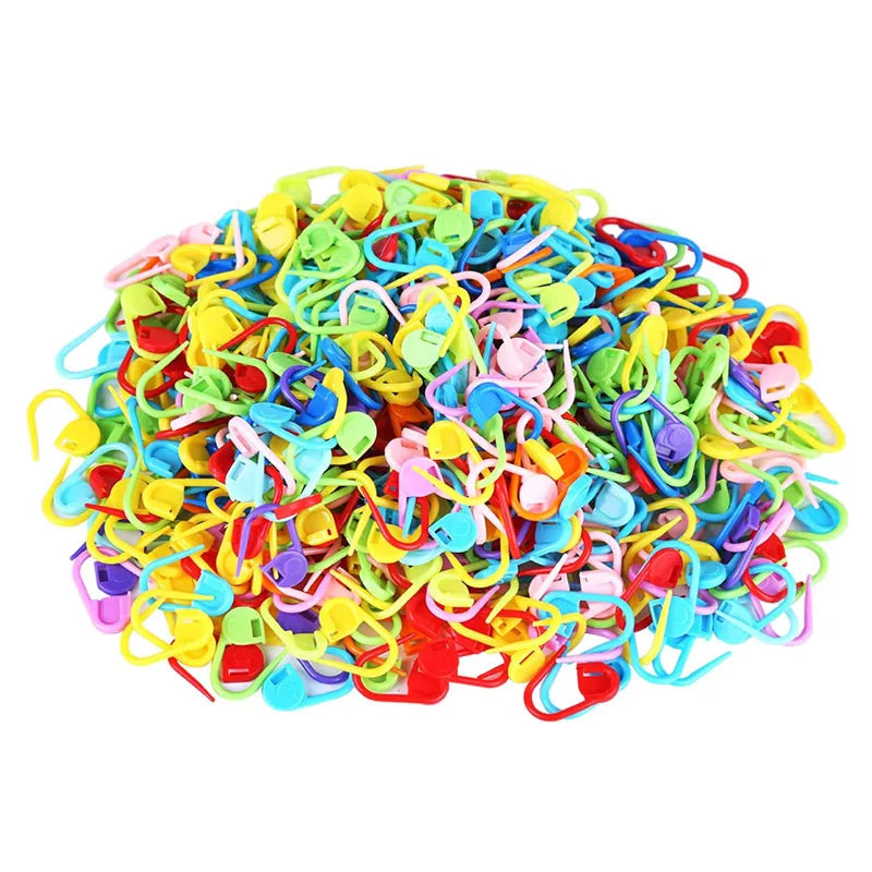 A pile of colorful locking stitch markers used for knitting and crochet projects.